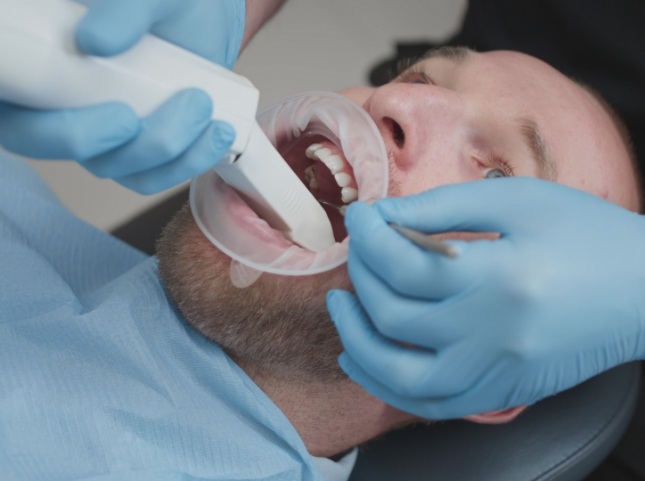 Dentist using a cavity detection scanner on a patient