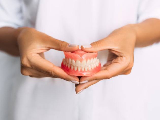 Lady presents viewer with dentures