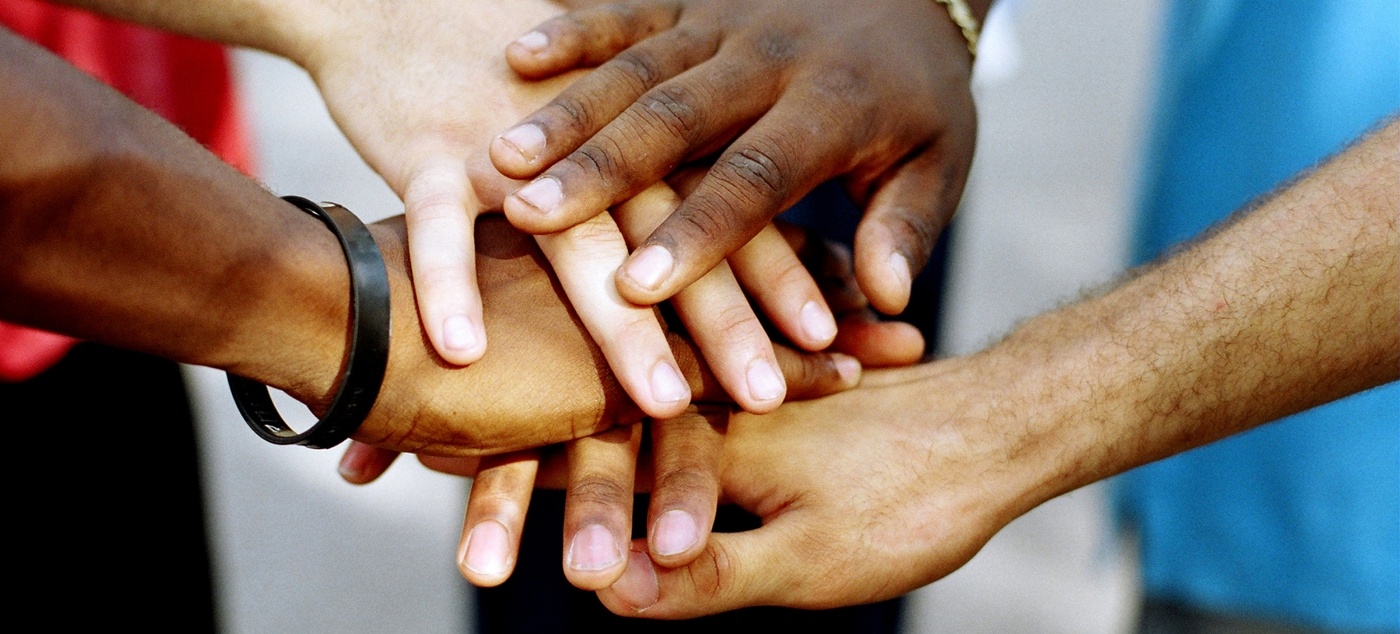 Huddle of people putting their hands together