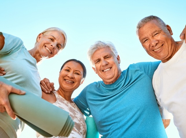 Four adults outdoors in exercise clothing