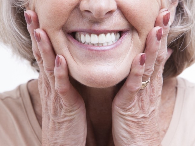 Smiling senior woman touching her face