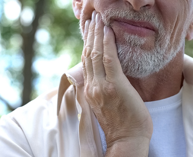 Closeup of man rubbing cheek