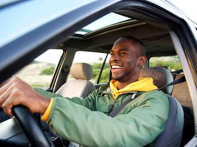 Man smiles in car