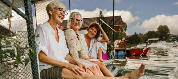 Three senior women laughing on the beach