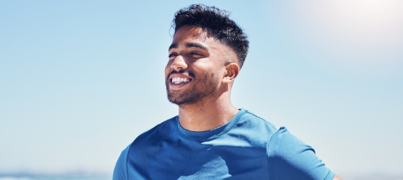 Man in blue T shirt smiling outdoors