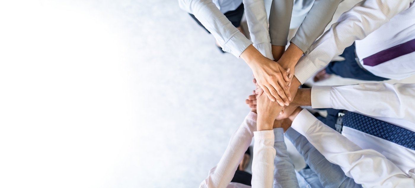 Circle of people placing their hands in the middle