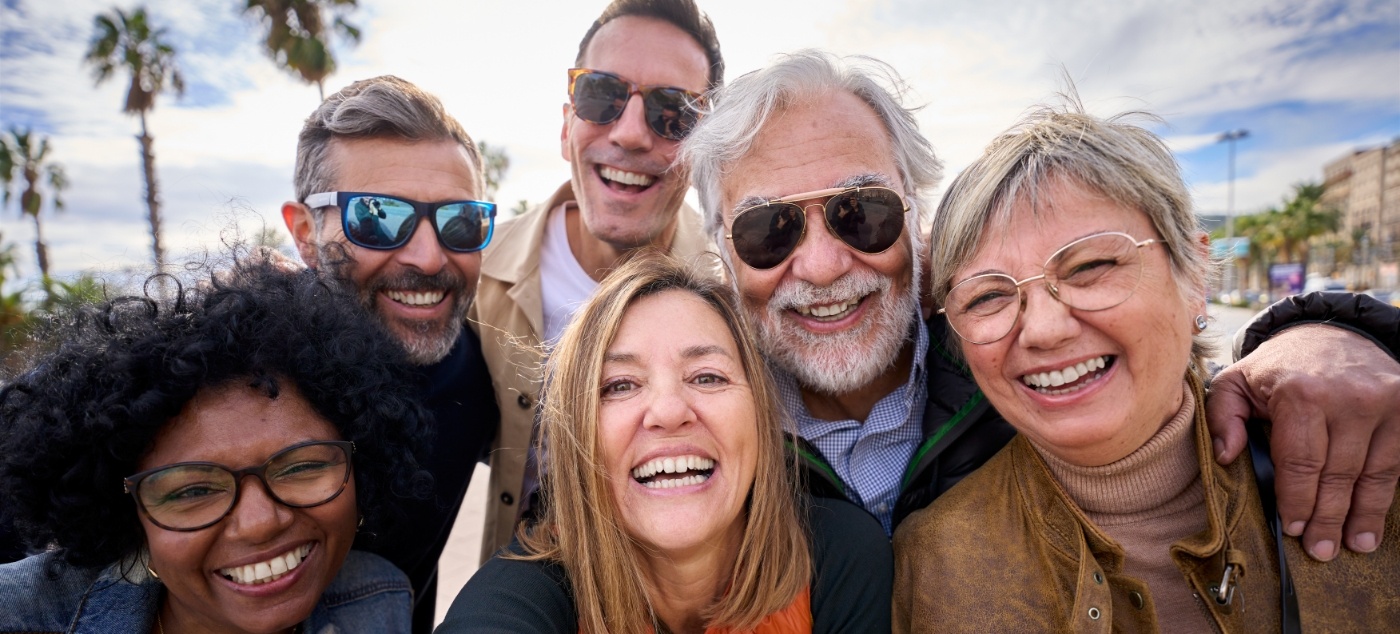 Group of older adults smiling after replacing missing teeth in Dublin