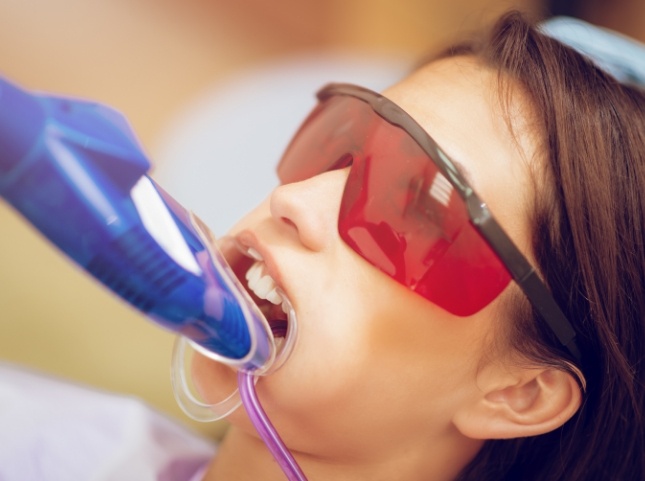 Girl in dental chair receiving fluoride on her teeth