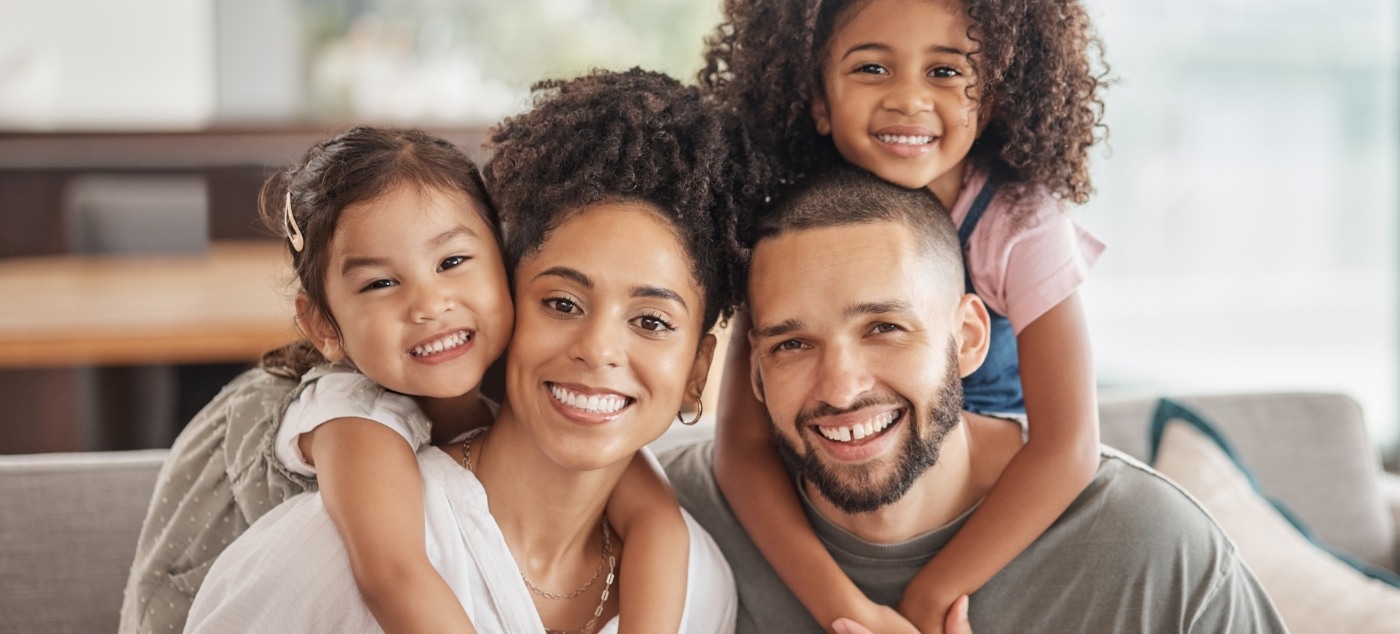 Family of four smiling at home