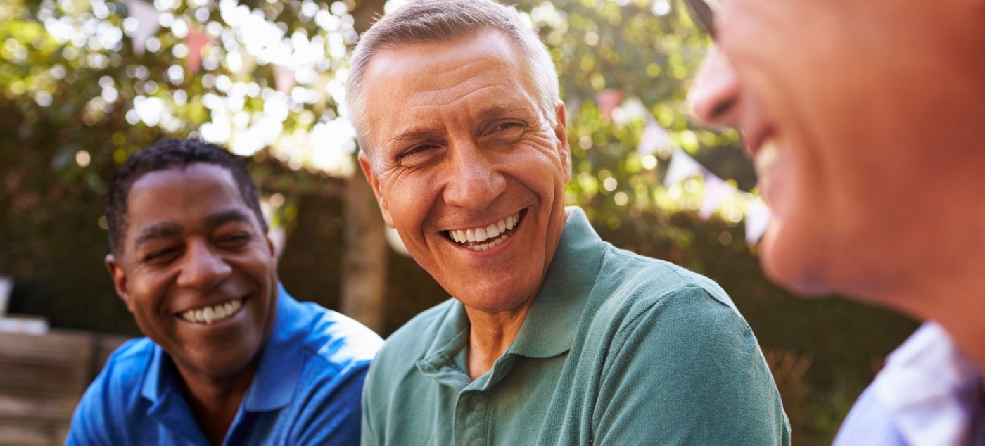 Three men laughing together outdoors after sedation dentistry in Dublin