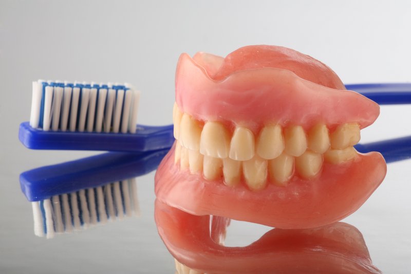 full set of dentures and a toothbrush