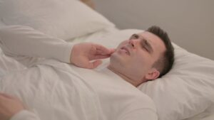 Man lying in bed with toothache.