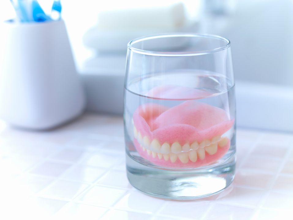 Dentures soaking in a glass of water